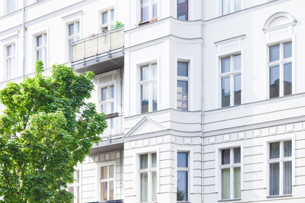 Weiß gestrichene Altbaufassade mit Stuck und Balkonen in einer Innenstadtlage