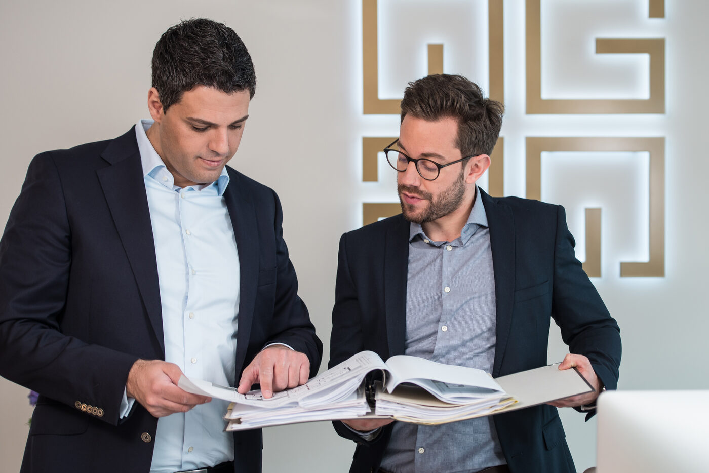 Zwei Mitarbeiter von GOLD IMMOBILIEN prüfen gemeinsam Objektunterlagen