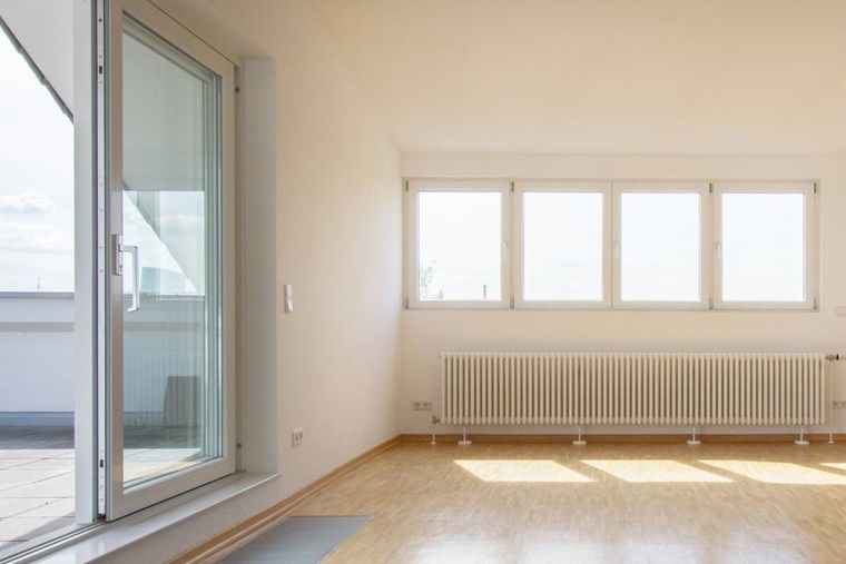 Helle leere Wohnung mit Balkontür und Fensterfront