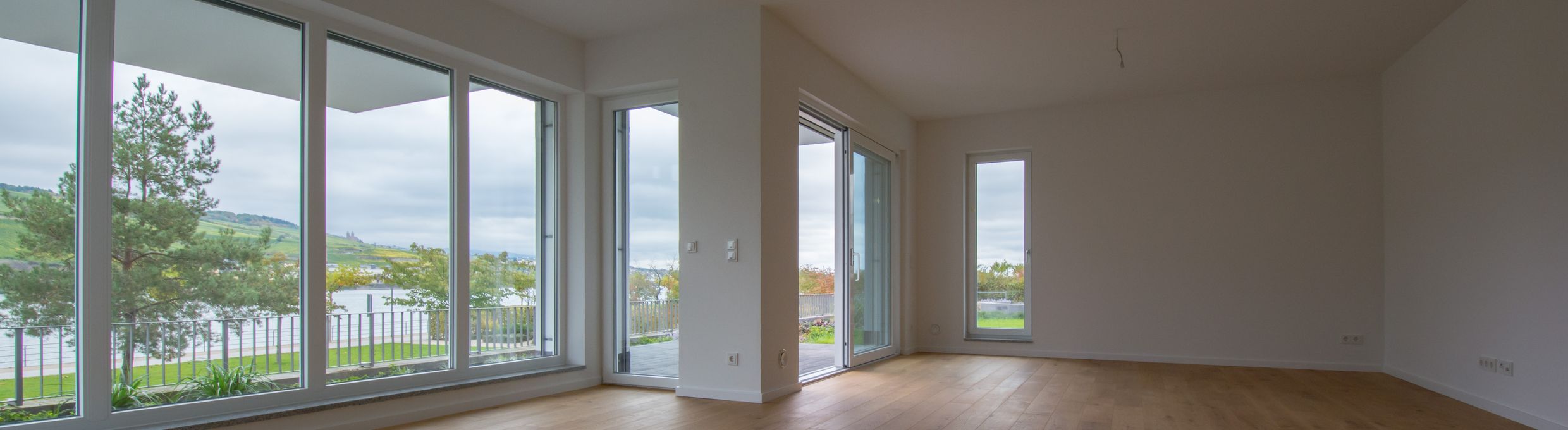 Leere Wohneinheit mit bodentiefer Fensterfront in einer Wohnanlage