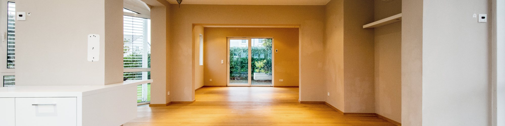 Leere geräumte Wohnung mit Blick in den Garten, aufgenommen vor der Vermarktung