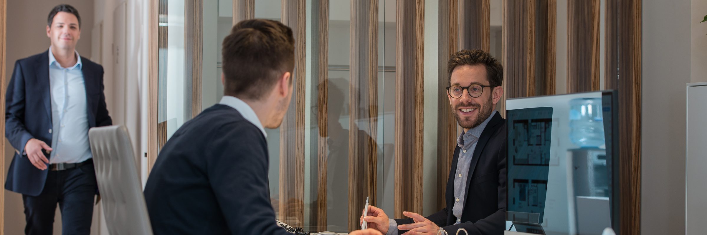 Gespräch am Schreibtisch im Büro von GOLD IMMOBILIEN