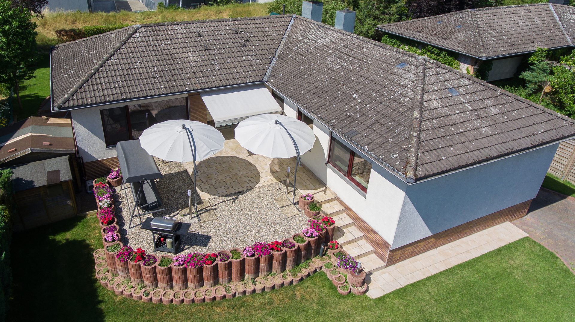 Senkrechte Luftaufnahme eines Wohnhauses mit Terrasse und Garten